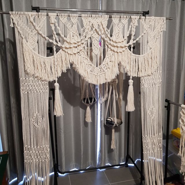 Macrame Wedding Backdrop An intricate, handcrafted cream macrame wedding backdrop with detailed knots, tassels, and fringed edges, perfect for ceremonies.