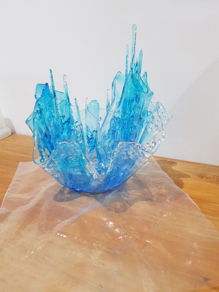 Resin Splash Blue resin sculpture resembling a splash on a wooden surface